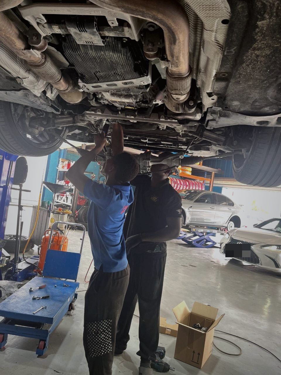 Technicians working under a lifted car